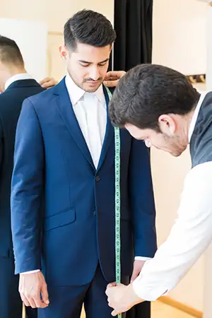 Groom getting measured before ordering his tuxedo