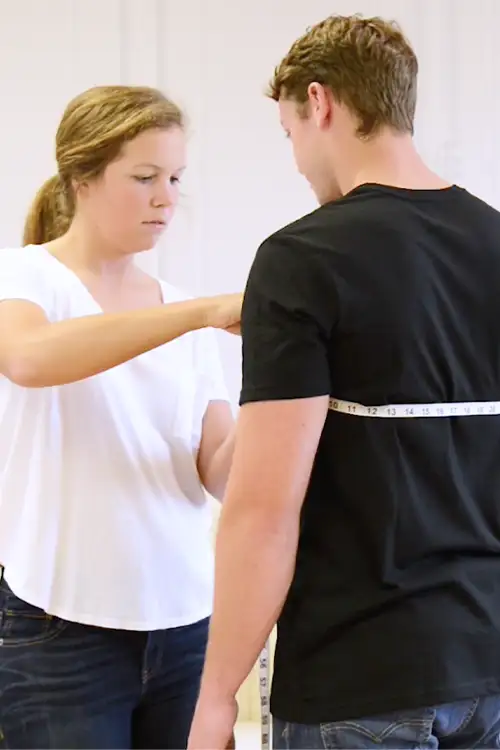 Friend helping groom get measured