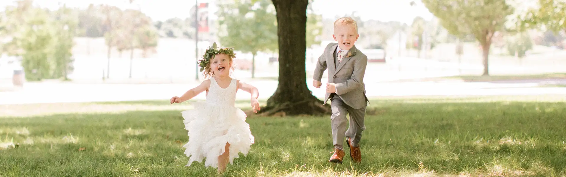 Ring bearer and Flower Girl running in a field