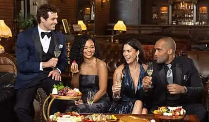 A group of teens with vibrant tuxedos and dresses in prom