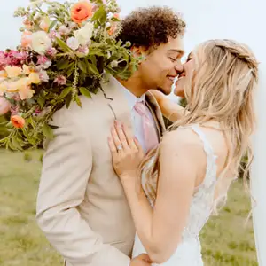Groom and bride about to kiss in a tan suit and wedding dress