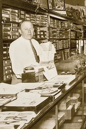 Leo Davis standing behind the counter of Jim's Formal Wear