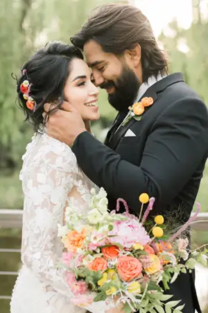 Groom and bride smiling in a black tuxedo