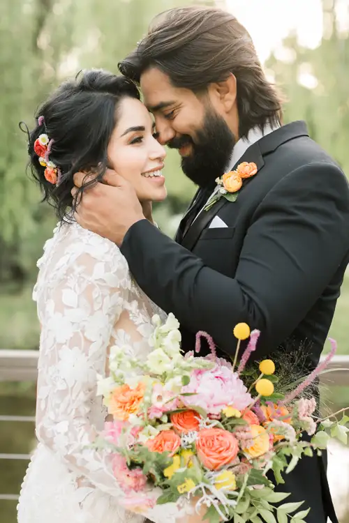 Groom and bride smiling in a black tuxedo